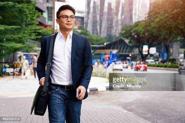 businessman walking in downtown kuala lumpur malaysia - chinese ethnicity stock pictures, royalty-free photos & images