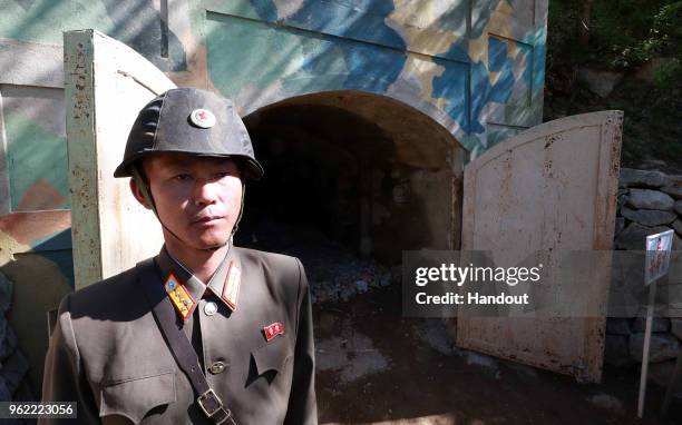 In this handout image provided by the News1-Dong-A Ilbo, a North Korean soldier stands at the entrance to a tunnel at the Punggye-ri nuclear test...