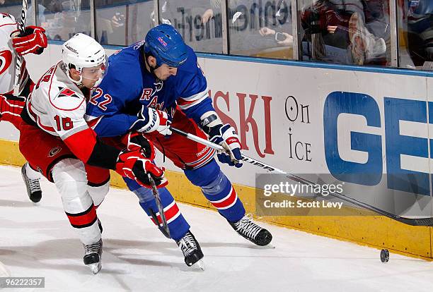 Brian Boyle of the New York Rangers skates with the puck along the boards against Brandon Sutter of the Carolina Hurricanes on January 27, 2010 at...