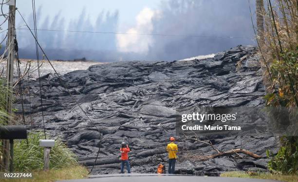 Workers observe lava from a Kilauea volcano fissure in Leilani Estates, on Hawaii's Big Island, on May 24, 2018 in Pahoa, Hawaii. An estimated 40-60...