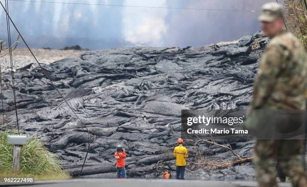 Workers observe lava from a Kilauea volcano fissure in Leilani Estates, on Hawaii's Big Island, on May 24, 2018 in Pahoa, Hawaii. An estimated 40-60...