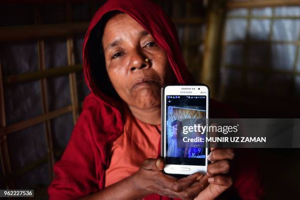 In this photograph taken on April 7 Rohingya Muslim refugee Khadija Begum, the mother of 16-year-old Rohingya youth Robi Alam, shows a photograph of...