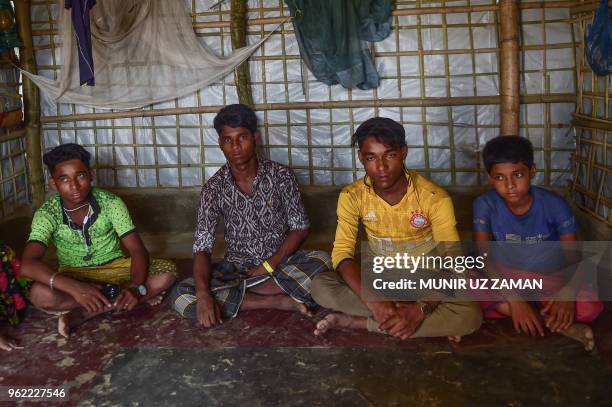 In this photograph taken on April 7 Rohingya Muslim refugees Robi Alam Mohammad Hashim Mohammad Jaber and Abul Faiz pose for a photograph at their...