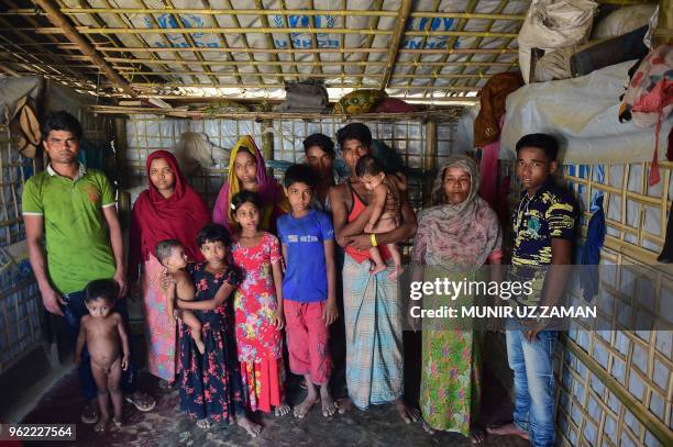 In this photograph taken on April 8 Rohingya Muslim refugee Robi Alam poses for a photograph with his family at their house in Kutupalong refugee...