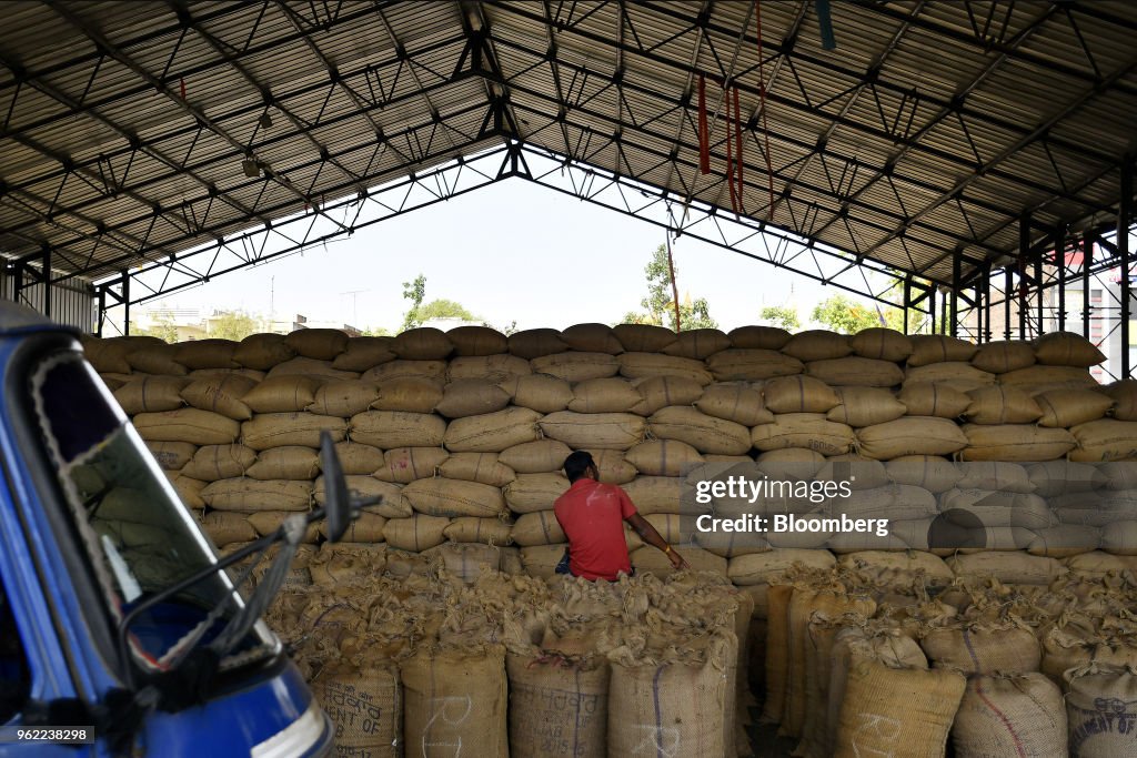 A man sits on sacks of grain at a wholesale grain market in