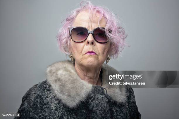 excentrieke senior dame met koele houding portret - alleen seniore vrouwen stockfoto's en -beelden