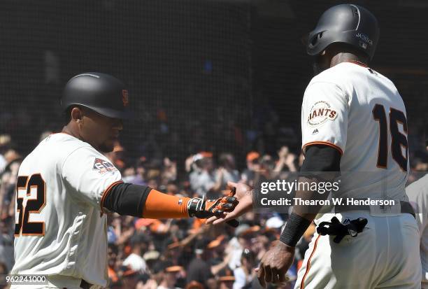 Miguel Gomez and Austin Jackson of the San Francisco Giants slap hands and celebrates after they both scored on an rbi two-run double from Andrew...