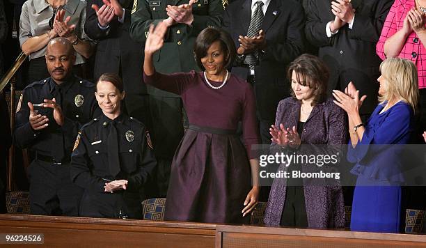 First Lady Michelle Obama, center, waves as she arrvies to hear U.S. President Barack Obama, unseen, deliver the State of the Union address to...