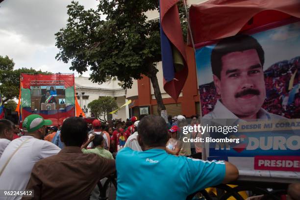 Attendees watch a screen showing a broadcast of Venezuela President Nicolas Maduro speaking at a swearing-in ceremony in Caracas, Venezuela, on...