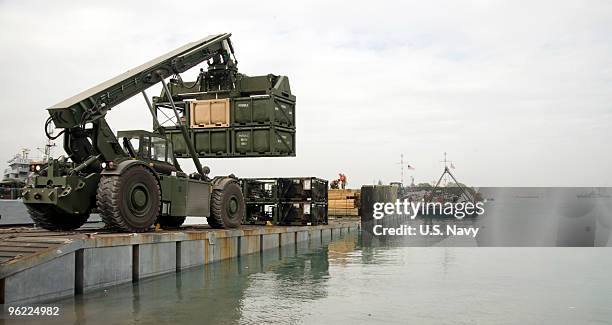 Marines assigned to 8th Engineer Support Battalion unload supplies from a floating causeway offloaded from the Military Sealift Command maritime ship...