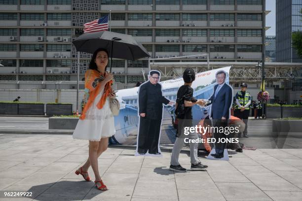 People walk past cardboard cutouts of North Korean leader Kim Jong Un and South Korean leader Moon Jae-in following a rally by an anti-US group...