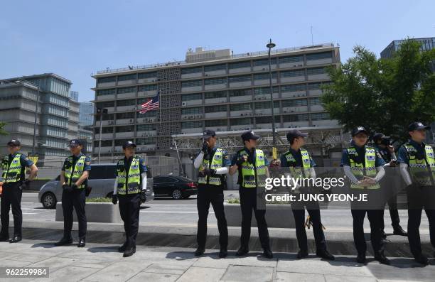 Police officers stand guard during a rally by anti-Trump protesters near the US embassy in Seoul on May 25, 2018. - South Korea's Unification...