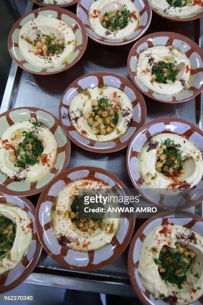 Plates of hummus are lined up ahead of the 'Iftar' meal to break the fast during the Muslim holy fasting month of Ramadan at a kitchen on Beirut's...