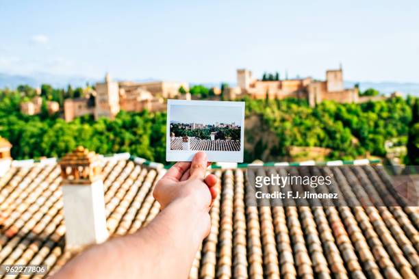 hand holding instant photo of the alhambra, granada - granada spain landmark - fotografias e filmes do acervo