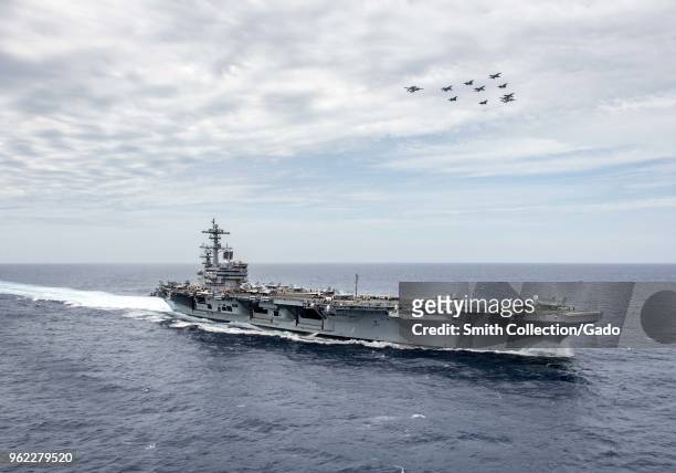 Photograph of aircraft flying in formation over the aircraft carrier USS George HW Bush during a joint training exercise involving US and French...