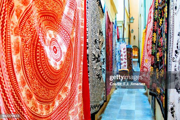 carpets in store stalls in granada, spain - bazaar stock-fotos und bilder