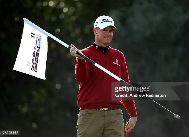 Robert Karlsson of Sweden holds the flag on the 11th hole during the first round of the Commercialbank Qatar Masters at Doha Golf Club on January 28,...