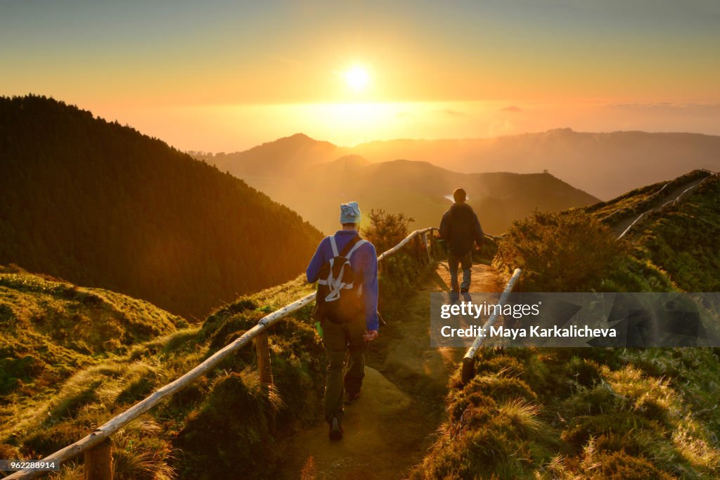 Friends walking at sunset at Sete Cidades lakes, Sao Miguel island, Azores, Atlantic ocean, Portugal