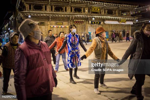 Locals seen performing a traditional dance during the night in the old town of Shangri-La.