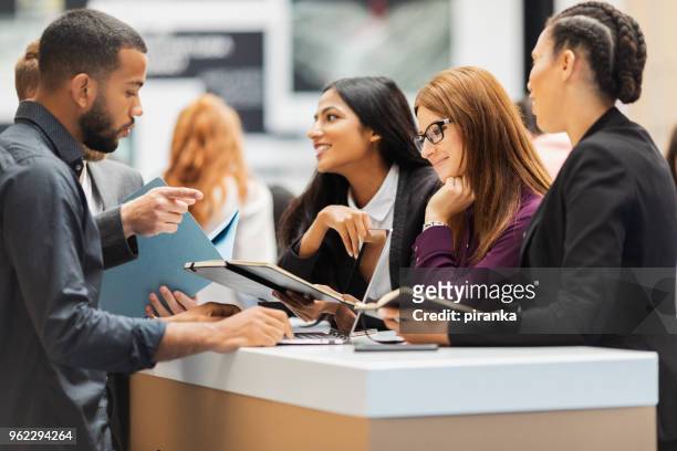 business people attending an exhibition - exhibition stock pictures, royalty-free photos & images