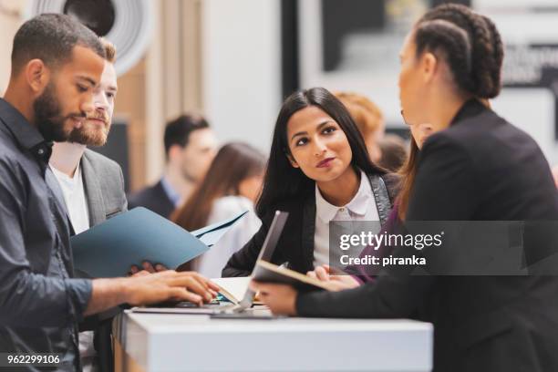 mensen uit het bedrijfsleven het bijwonen van een tentoonstelling - tentoonstelling stockfoto's en -beelden