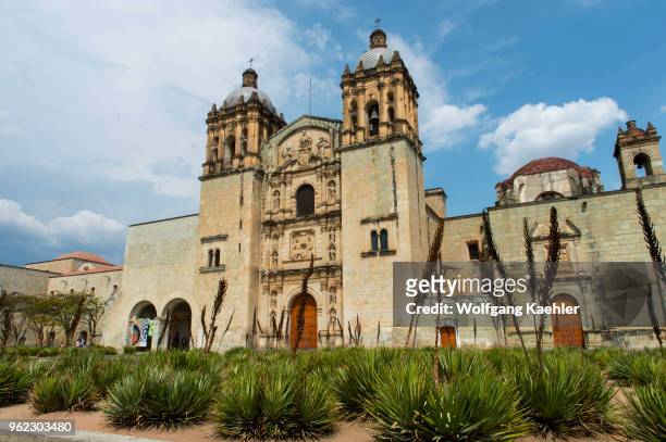 The Plaza Santo Domingo and the Baroque ecclesiastical Church of Santo Domingo de Guzman with agave plants in the foreground in the city of Oaxaca de...