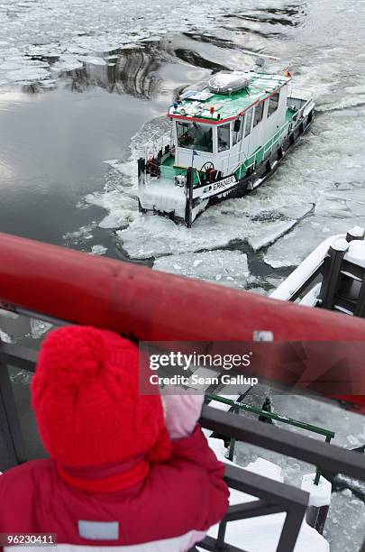 Child watches an icebreaker churn through ice in the Dahme river in the district of Koepenick on January 28, 2010 in Berlin, Germany. Though...