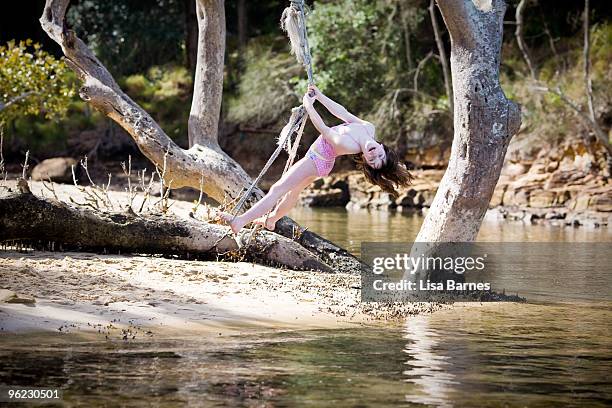 girl swinging on rope over water - pittwater stock pictures, royalty-free photos & images