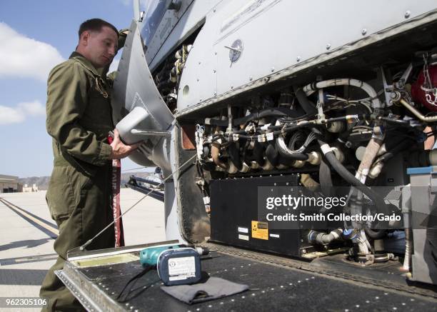 Helicopter airframe mechanic Lance Cpl Justin Warnick putting a hatch on to an AH-1Z Viper helicopter, Marine Corps Air Station Camp Pendleton,...