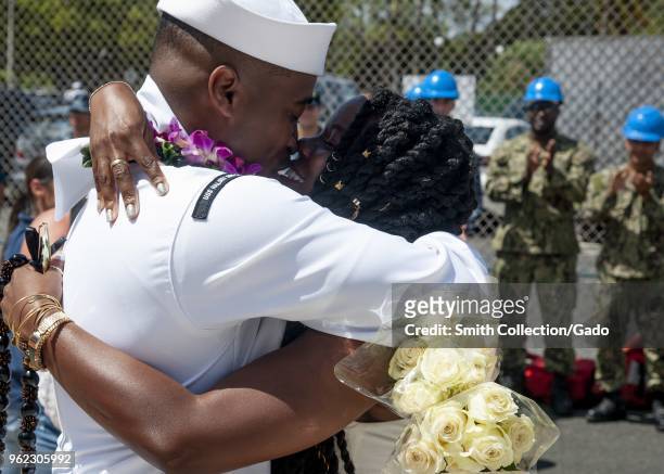 Intelligence Specialist 1st Class Dee-Mar-Kee H. Aytche hugging his wife, celebrating the arrival of the Arleigh Burke-class guided-missile destroyer...