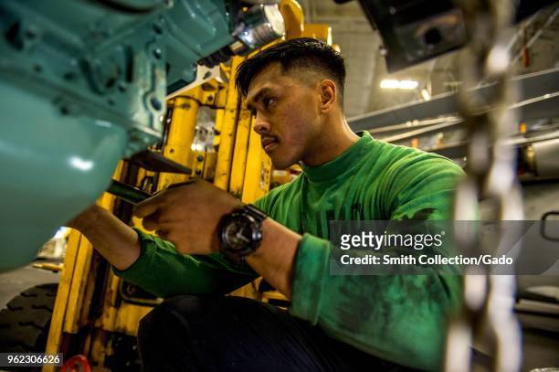 Photograph of Aviation Support Equipment Technician 3rd Class Anthony Delrosario conducting maintenance aboard the aircraft carrier USS George HW...