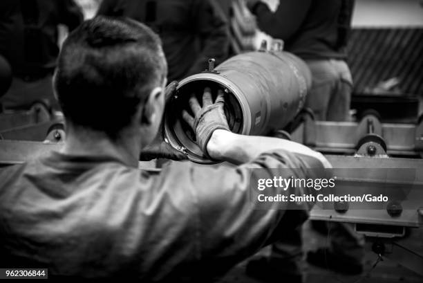 Photograph of a French sailor assisting in a simulated bomb build aboard the aircraft carrier USS George HW Bush as part of a project to strengthen...