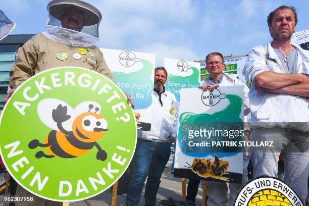 Protester holds a sign reading "agrarian poison- no thanks" during a demonstration against the takeover of US seeds and pesticides maker Monsanto by...