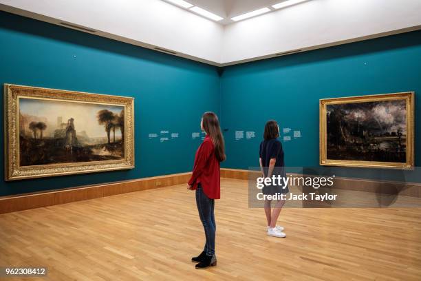 Tate employees pose with 'Salisbury Cathedral from the Meadows', 1831 by John Constable and William Turner's 'Caligula's Palace and Bridge', also...