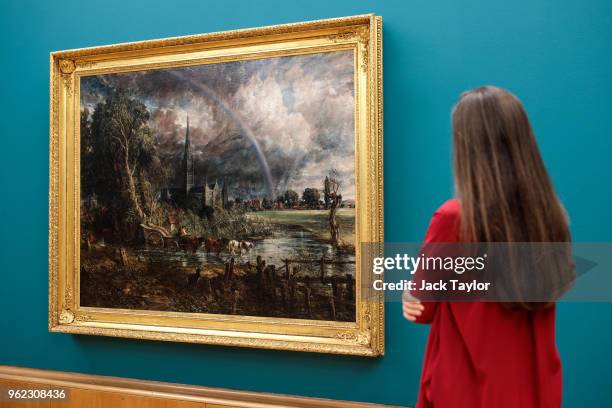 Tate employee poses with 'Salisbury Cathedral from the Meadows', 1831 by John Constable during a photo call at Tate Britain on May 25, 2018 in...