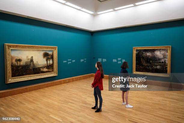 Tate employees pose with 'Salisbury Cathedral from the Meadows', 1831 by John Constable and William Turner's 'Caligula's Palace and Bridge', also...