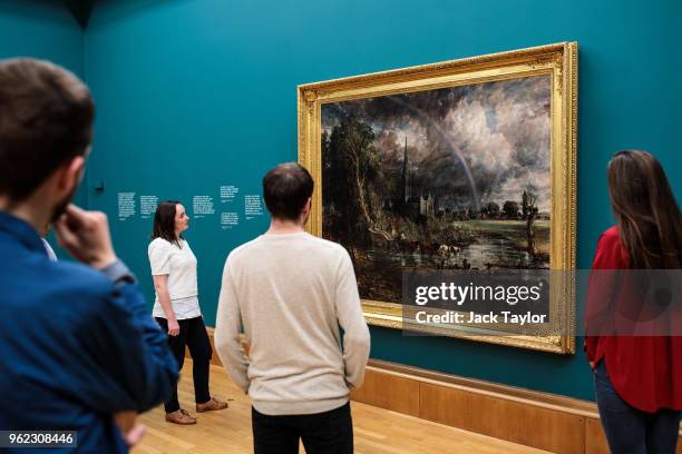 Tate employees pose with 'Salisbury Cathedral from the Meadows', 1831 by John Constable during a photo call at Tate Britain on May 25, 2018 in...
