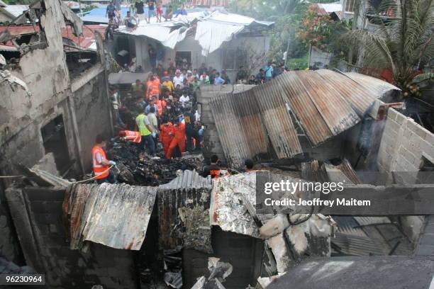 Filipino rescuers attend the site of a Philippine Air Force plane crash on January 28, 2010 in the southern city of Cotabato, Maguindanao Province,...