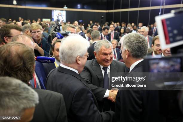 Igor Sechin, chief executive officer of Rosneft PJSC, center, greets attendees following a panel debate at the St. Petersburg International Economic...