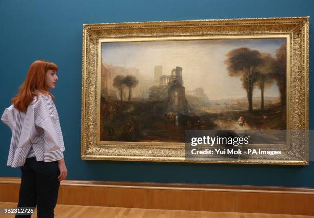 Member of staff looks at Joseph Mallord William Turner's Caligula's Palace and Bridge during a photo call for Tate Britain's new exhibition, Fire and...