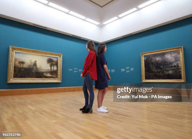 Gallery staff looking at Joseph Mallord William Turner's Caligula's Palace and Bridge and John Constable's Salisbury Cathedral from the Meadows...