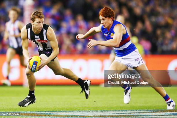 Will Hoskin-Elliott runs with the ball from Ed Richards of the Bulldogs during the round 10 AFL match between the Collingwood Magpies and the Western...