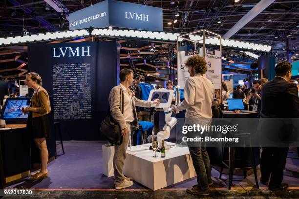 Attendees visit the LVMH Moet Hennessy Louis Vuitton SE exhibition stand during the Viva Technology conference in Paris, France, on Thursday, May 24,...