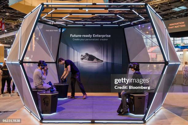 Visitors wear augmented reality headsets on the SAP SE booth during the Viva Technology conference in Paris, France, on Thursday, May 24, 2018. Viva...