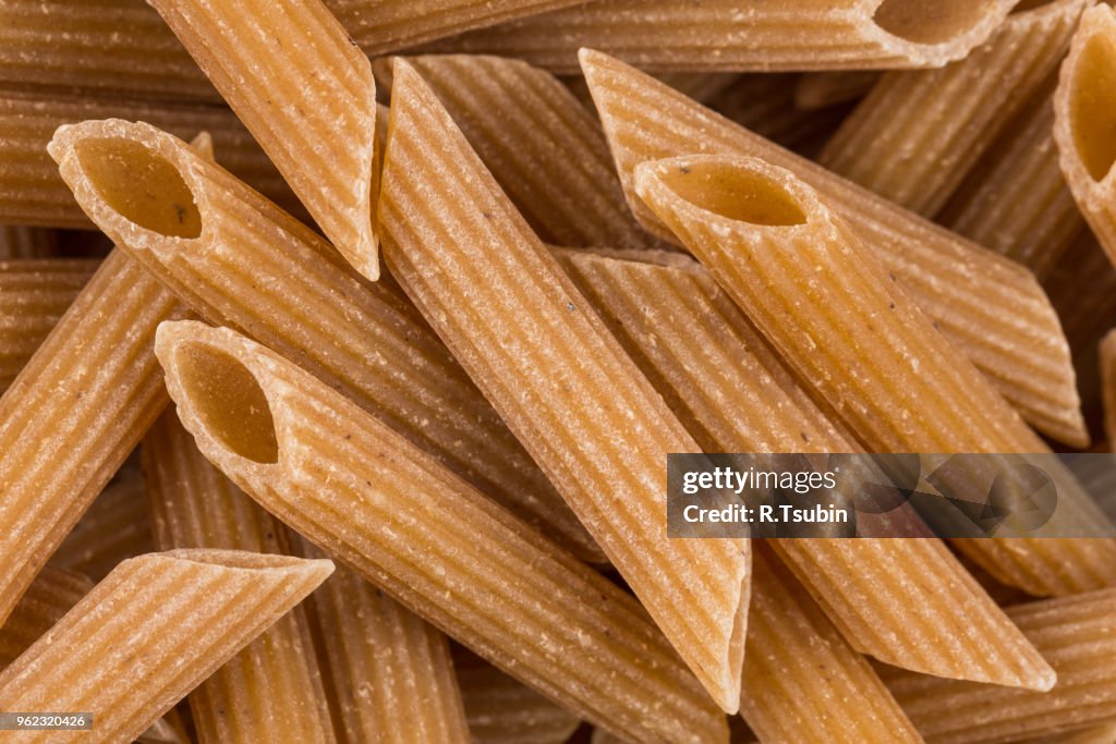 Wholemeal Pasta Penne as close-up shot for background