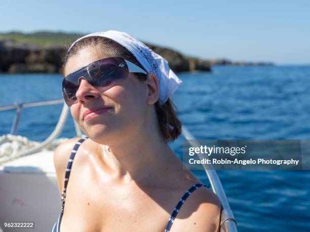 a women on a boat on a sunny day - robin angelo photography stock-fotos und bilder