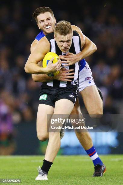 Marcus Bontempelli of the Bulldogs tackles Jordan de Goey of the Magpies during the round 10 AFL match between the Collingwood Magpies and the...