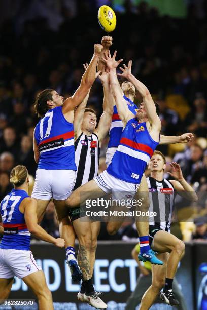 Jordan de Goey of the Magpies is crunched by Tom Boyd of the Bulldogs Bailey Williams of the Bulldogs during the round 10 AFL match between the...