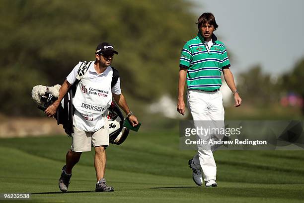 Robert Jan Derksen of The Netherlands walks with his caddie on the 18th hole during the first round of the Commercialbank Qatar Masters at Doha Golf...