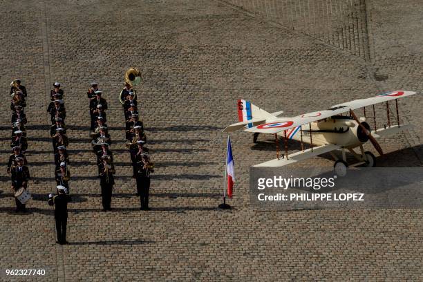 French military band performs next to a plane during a ceremony to celebrate the centenary of Britain's Royal Air Force at the hotel des Invalides in...